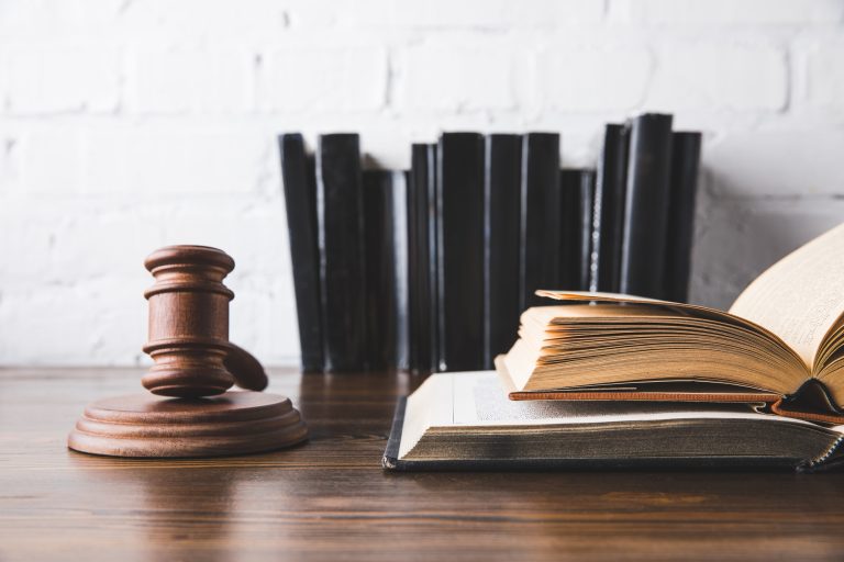 opened juridical books with gavel on wooden table, law concept